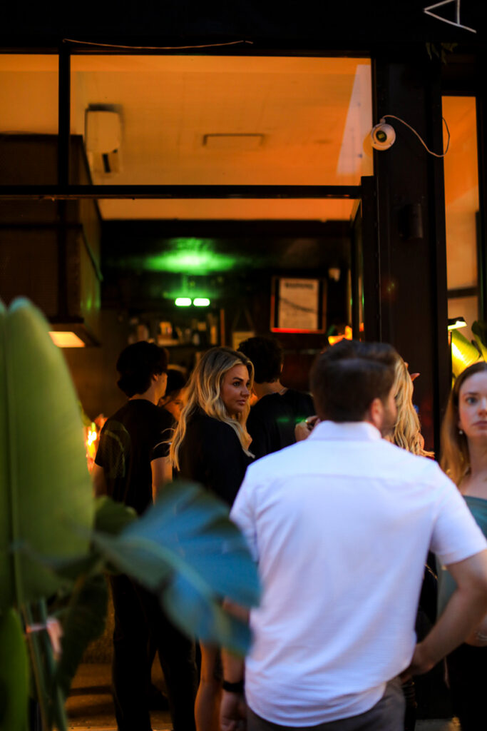 Guests talking near the restaurant entrance during an evening service.